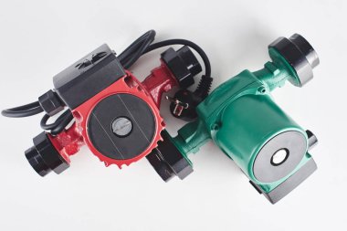 Red and green circulation pumps for heating on a white background. clipart