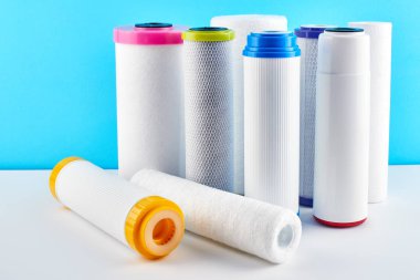 Su filtreleri. Mavi beyaz bir arka plan üzerinde karbon kartuşları. Ev filtreleme sistemi.