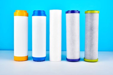 Su filtreleri. Mavi beyaz bir arka plan üzerinde karbon kartuşları. Ev filtreleme sistemi.