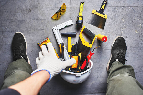 The concept of repair. Male hand reaching for construction tools. First person view.