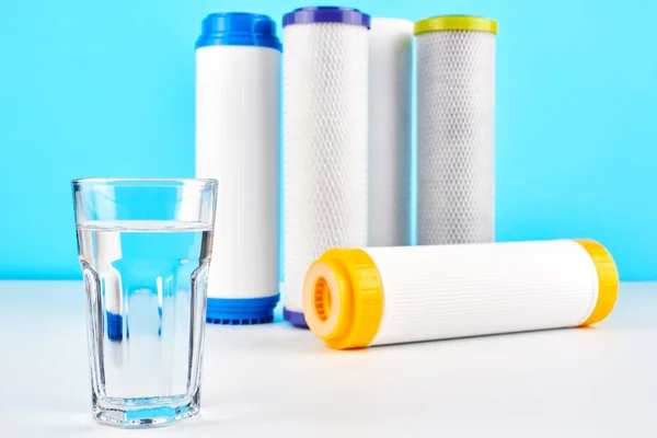 Vattenfilter Kolpatroner Och Ett Glas Vit Blå Bakgrund Hushållens Filtreringssystem — Stockfoto