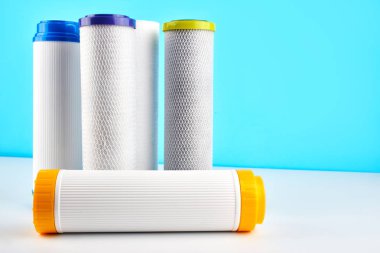 Su filtreleri. Mavi beyaz bir arka plan üzerinde karbon kartuşları. Ev filtreleme sistemi.
