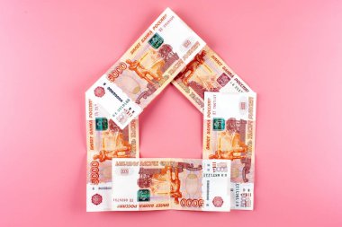 Ruble. Pembe bir arka plan üzerinde bir ev şeklinde Rus parası. Emlak Kredi kavramı