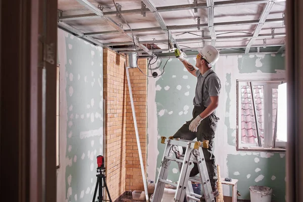 Zimmerreparatur Innenausbau Junger Bauarbeiter Fertigt Eine Gipskartondecke Die Auf Einer — Stockfoto