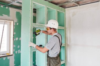 Oda onarım. Bina. İşçi drywall bir tornavida ile takılır. 
