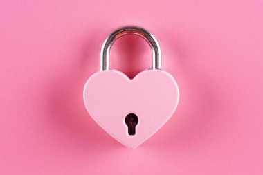 Pembe bir arka plan üzerinde bir kalp şeklinde kilit