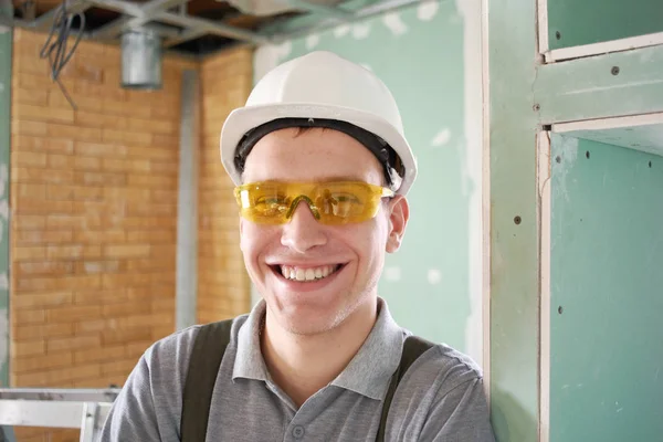 Reparación Joven Constructor Sonriente Casco Gafas Levanta Sobre Fondo Una — Foto de Stock