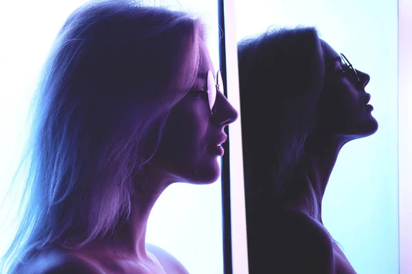 青いネオンが創造的な照明の背景にガラスと美しい若い金髪女性のプロファイルのコラージュ — ストック写真