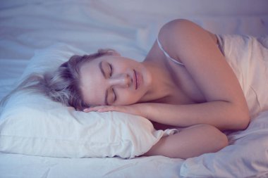 kız gece aydınlatma ile bir Ortopedik yastık üzerinde uyku, beyaz keten