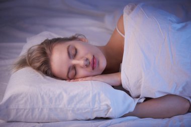kız gece aydınlatma ile bir Ortopedik yastık üzerinde uyku, beyaz keten