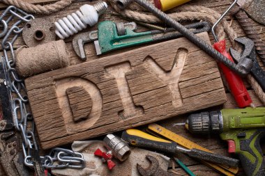 Bir ahşap tahta üzerinde çalışan araçlar arka plan DIY harfler. It Yourself konsepti yapmak.