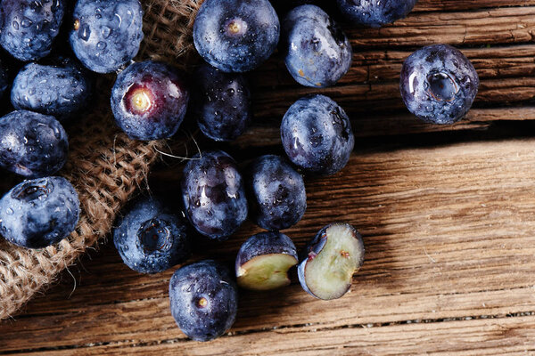 Fresh raw blueberries on wooden background close up