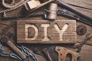 Bir ahşap tahta üzerinde çalışan araçlar arka plan DIY harfler. It Yourself konsepti yapmak.