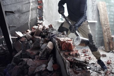 Bir adam tamirci bir tuğla duvar çekiçle kırar, oluşturur ve evini tamir