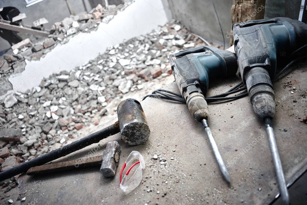 Repair and building a house. Construction tools, jackhammer on the floor of the destroyed building