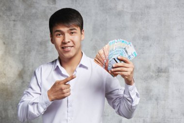 Elinde kazak tenge demet ile Asyalı işadamı. Başarılı girişimci işlemler ve hisse senedi satışı çok para kazandı.