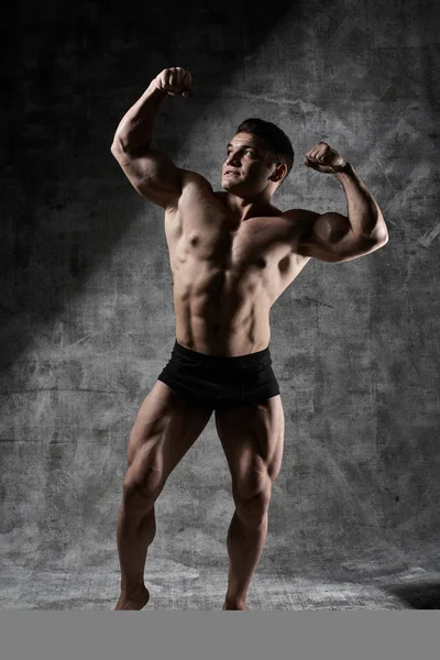 Uomo Bodybuilder Sexy Posa Piena Crescita Sfondo Scuro Pantaloncini Neri — Foto Stock