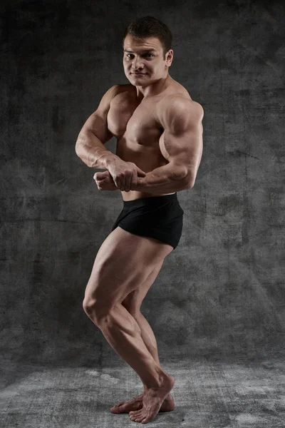 Uomo Bodybuilder Sexy Posa Piena Crescita Sfondo Scuro Pantaloncini Neri — Foto Stock