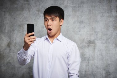 Asya Kazak açık ağız ile şaşırttı akıllı telefon bakar, o telefonda gördükleri ile şok