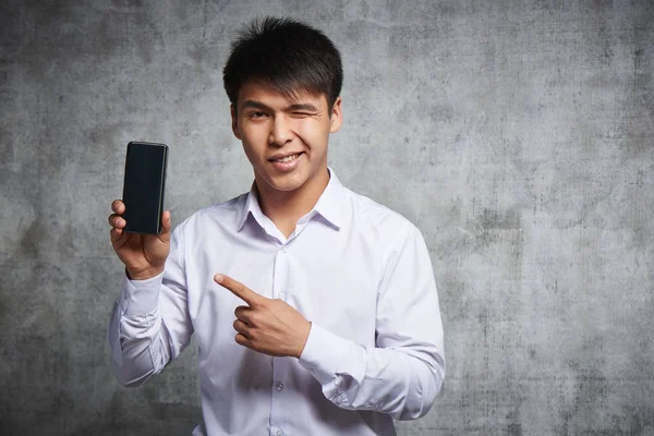 Asiático Alegre Apontando Para Telefone Celular Com Dedo Indicador Anunciando — Fotografia de Stock