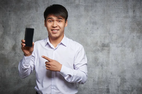 Joyful Asian Apuntando Teléfono Móvil Con Dedo Índice Anunciando Algo —  Fotos de Stock