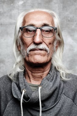 Gözlük ile yaşlı gri saçlı Kafkas adam emeklinin portresi. Gri arka planda kamera bakarak bıyık ve ciddi yüz ile Cool Büyükbaba