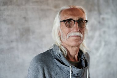 Gözlüklü yaşlı gri saçlı Beyaz adam emekli portresi. Bıyık lı serin dede ve gülümseyen nazik dost suratlı, fotokopi alanı ile gri arka planda kameraya bakan