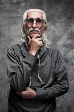 Yaşlı gri saçlı Beyaz emekli adam hayatı düşünüyor. Bıyıklı ve düşünceli yüz ifadesi ile gözlük büyükbaba çenesini tutar