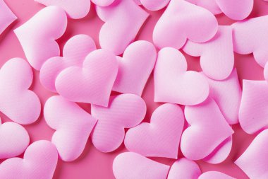 Aşk ile Sevgililer Günü için pembe bir arka plan üzerinde birçok hacimsel kalpler
