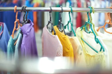 İkinci el bir mağazada askılar üzerinde asılı çok renkli giysiler