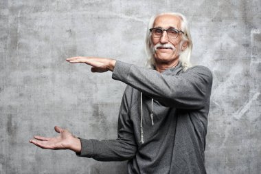 Gözlük ile gri saçlı Kafkas Büyükbaba elinde bir şey tutarak gibi davranan, gri arka plan izole ürün reklam