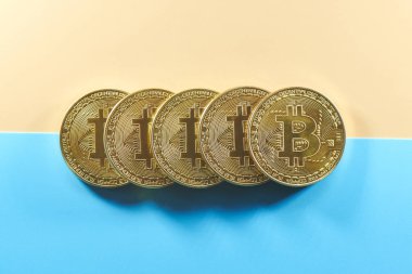 Sarı mavi bir arka plan üzerinde fiziksel altın sikke bitcoins. Dijital kripto para birimi kavramı