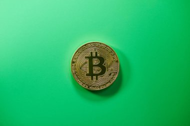 Yeşil arka planda fiziksel altın sikke bitcoin. Dijital kripto para birimi kavramı