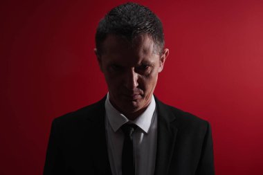 Kötü patron. Öfke ile kırmızı gözlü bir iş elbisesi içinde öfkeli bir adam portresi. Saldırgan kişi