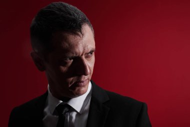 Kötü patron. Öfke ile kırmızı gözlü bir iş elbisesi içinde öfkeli bir adam portresi. Saldırgan kişi