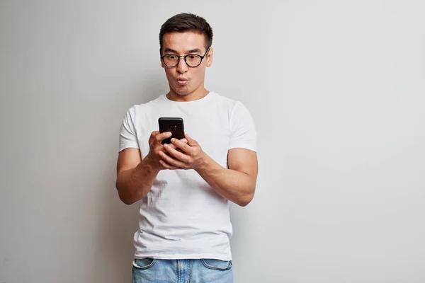 Guapo Asiático Chico Blanco Estudio Sorprendido Pantalla Teléfono Móvil Impresionado — Foto de Stock