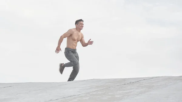 Asian athlete man jogging in the morning outdoors, Kazakh runner minimalism photo style