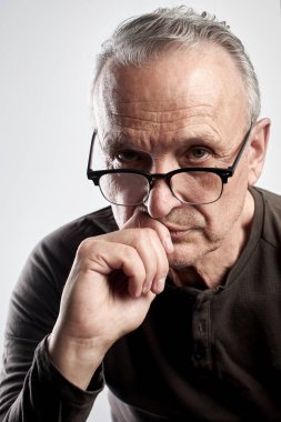 Stüdyoda beyaz bir arka plan üzerinde gözlük şık bir modern yaşlı adam Portresi. Kıdemli patron