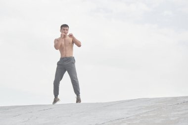 Asyalı atlet sabah ları açık havada antrenman yapıyor, Kazak güreşçinin minimalizm tarzında antrenman fotoğrafı