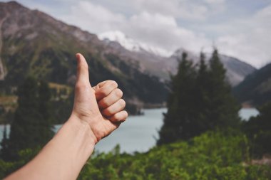 Almaty'deki Bao Dağı Gölü'nün arka planında başparmak. Güzel doğa, güneşli Kazakistan yaz yeşil manzara