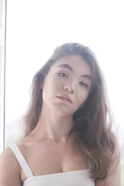 白い背景に長いブルネットの髪を持つセクシーなカザフスタンのモデルの女の子の肖像画 — ストック写真