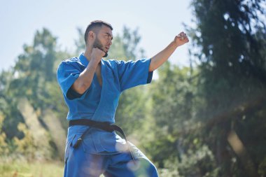 Asya Kazak karate savaşçı kopya alanı ile bir yaz güzel doğa manzara mavi kimono üniforma mücadele