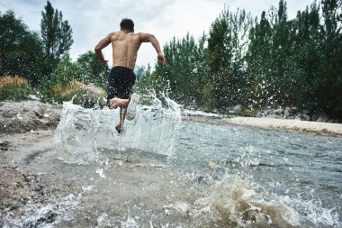 Nehirüzerinde bir sabah koşmak Asyalı atlet, doğada yakın çekim Kazak koşucu 