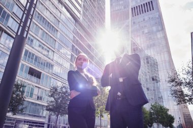 Bir cam binanın arka planına karşı iki iş ortağının toplantısı