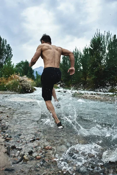 Asian athlete on a morning run on the river, Kazakh jogger in nature close-up