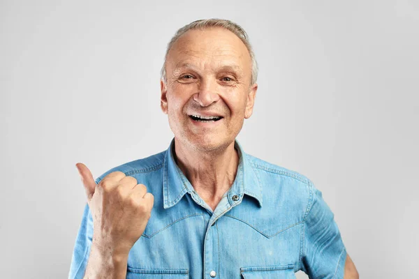 Positive Gray Haired Senior Citizen Joyfully Smiles Shows Finger Side — Stock Photo, Image