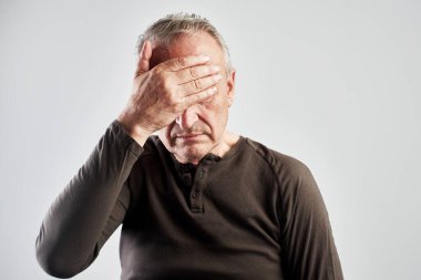 Yüzünde acı ifadesi olan yaşlı gri saçlı bir adam elini başının üstüne koydu, baş dönmesi ve küme baş ağrısı, migren, yüksek ya da düşük kan basıncı, beyaza izole edilmiş.