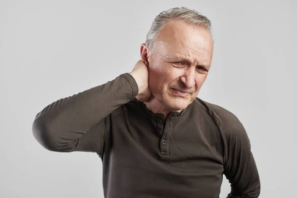 Stylish gray-haired old man grabbed his neck with pain on face white background. Osteochondrosis of cervical spine concept, back problems — Stock Image Stylish Gray Haired Old Man Grabbed His Neck Pain Face Stock Image