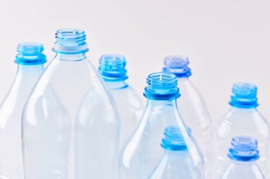 Maden suyu şişelerini beyaz arka planda farklı boyutlarda ve tipte ayırın. Plastik üretim ve işleme kavramı