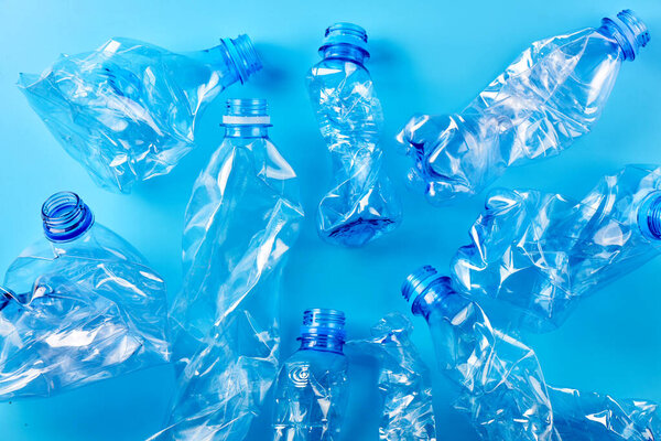 Empty crumpled plastic bottles pattern blue background. Recycling concept